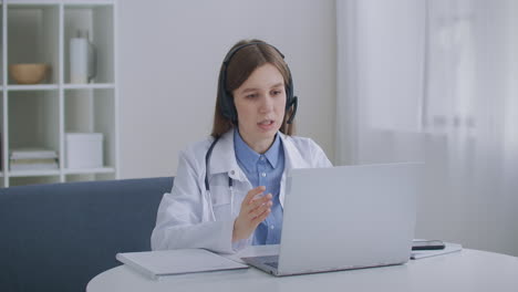 consulta del médico por teléfono la mujer médico está respondiendo a las preguntas de los pacientes en el centro de llamadas vista de perfil