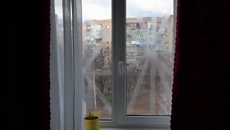 in kramatorsk, ukraine, a home window is taped for blast protection. this stark scene highlights urban war's impact and civilian resilience amidst the ukraine-russia conflict.