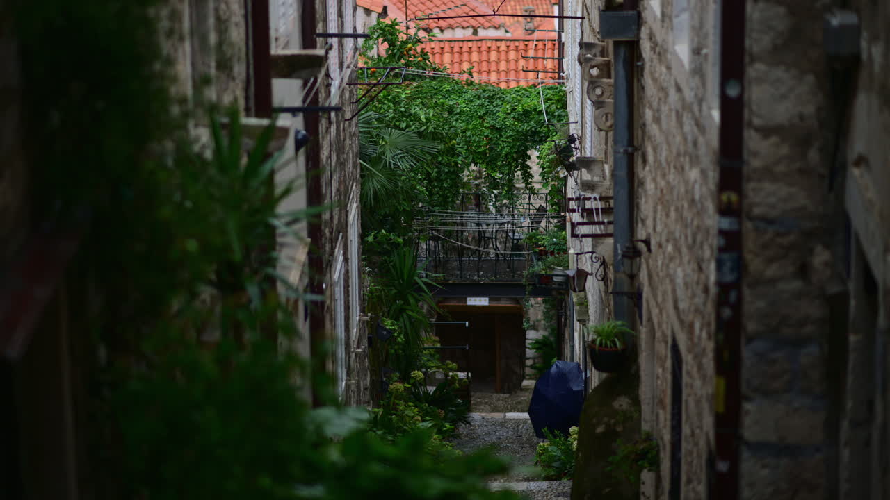 Scorcio di uno stretto vicolo in pietra, che rivela i tetti della città e le cupole delle cattedrali a Dubrovnik.