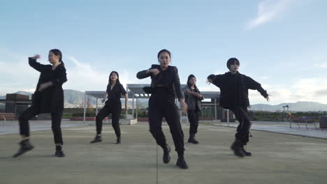 young street performer performing on the street. seven chinese teenagers dancing kpop