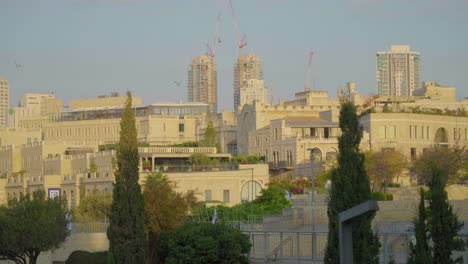 slow motion of birds flying overlooking jerusalem skyline and construction during sunrise