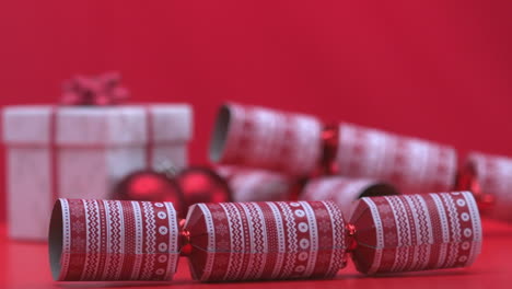 christmas cracker dropping and bouncing beside present and bauble