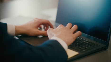 manager working on laptop at desk.