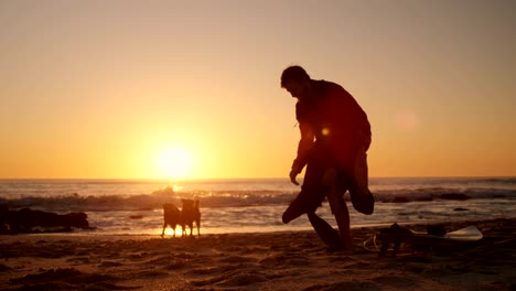 hombre con traje de neopreno en la playa 4k