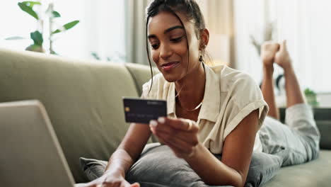 mujer, tarjeta de crédito y portátil en el sofá