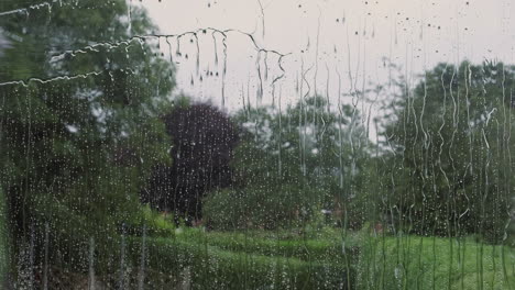 a window cleaner using a long pole and brush cleans a house window with ionised water, england