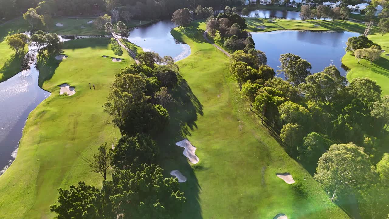 Drone captures a sweeping aerial view of a lush golf course with vibrant greenery and water features in Gold Coast, Australia