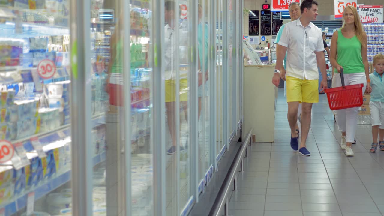 가족이 슈퍼마켓의 유제품 부문에서 음식을 먹고 있습니다.