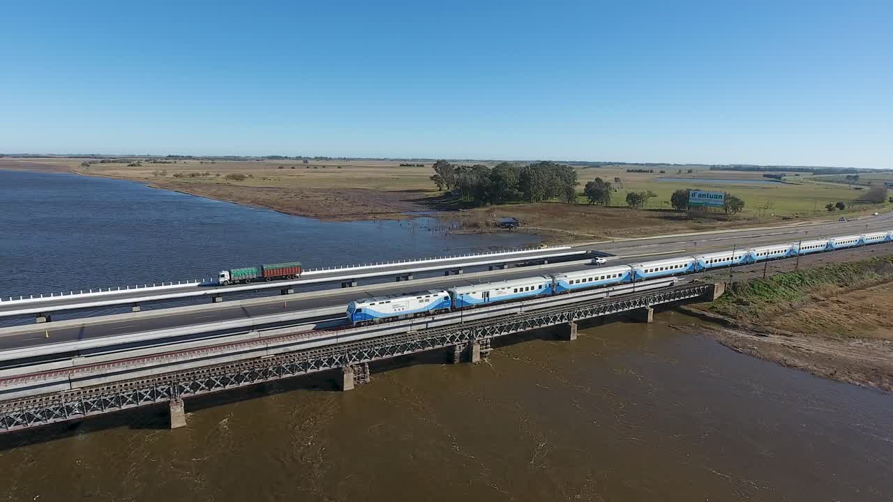 부에노스아이레스 교외 의 강 을 가로지르는 다리 를 건너고 있는 여객 열차 의 공중 사진