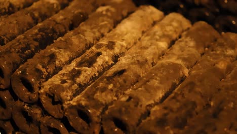 Detailed view of dusty wine bottle necks stacked in a dimly lit cellar.