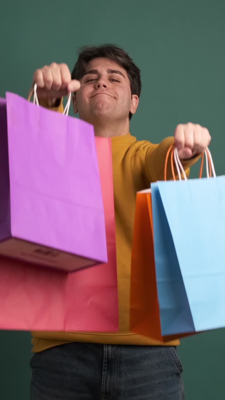 Happy ethnic young man showing shopping bags