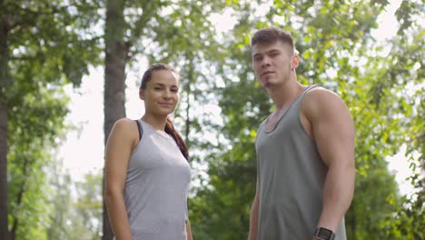 retrato de una pareja deportiva confiada mirando la cámara en un bosque