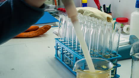 lapso de tiempo del técnico de laboratorio llenando viales con una solución amarilla
