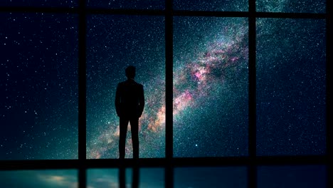 the male standing near the window on the starry sky background. time lapse