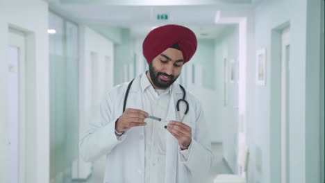 happy sikh indian doctor filling up an injection