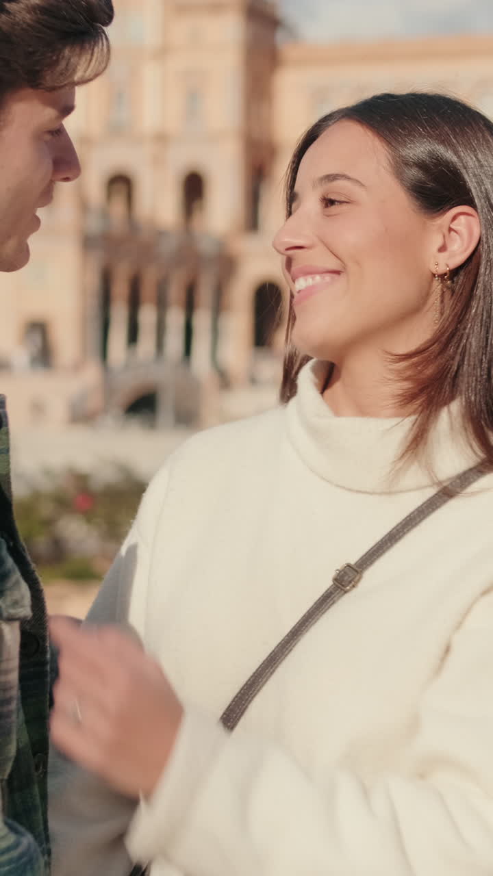 Happy young couple man and woman kissing while standing on bridge