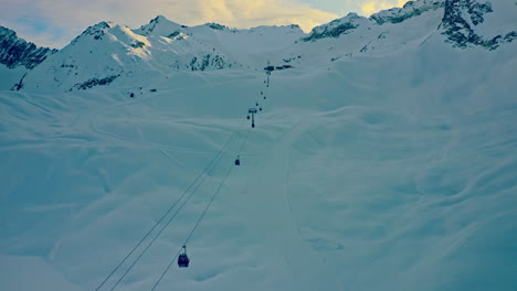 aerial view of ski elevator in mountain resort. 
drone shot of people transporting on ski lift on snowy mountain peak