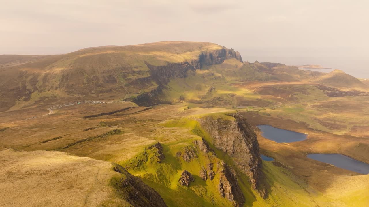 Aerial drone footage of the dramatic mountain landscapes on the Isle of Skye, Scotland. Sweeping panoramic views of majestic peaks, green valleys, and wild nature