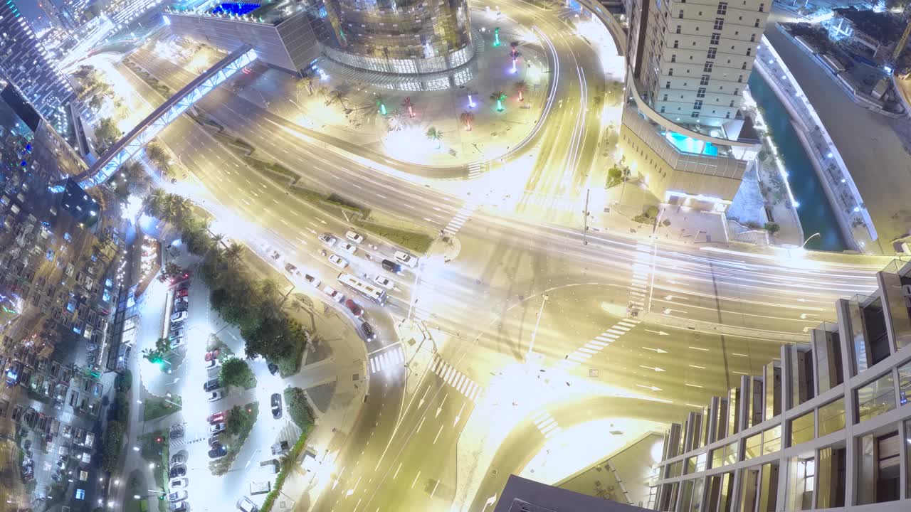Nighttime as vehicle traffic passes an intersection in Abu Dhabi - time lapse as seen from a tall building or aerial platform