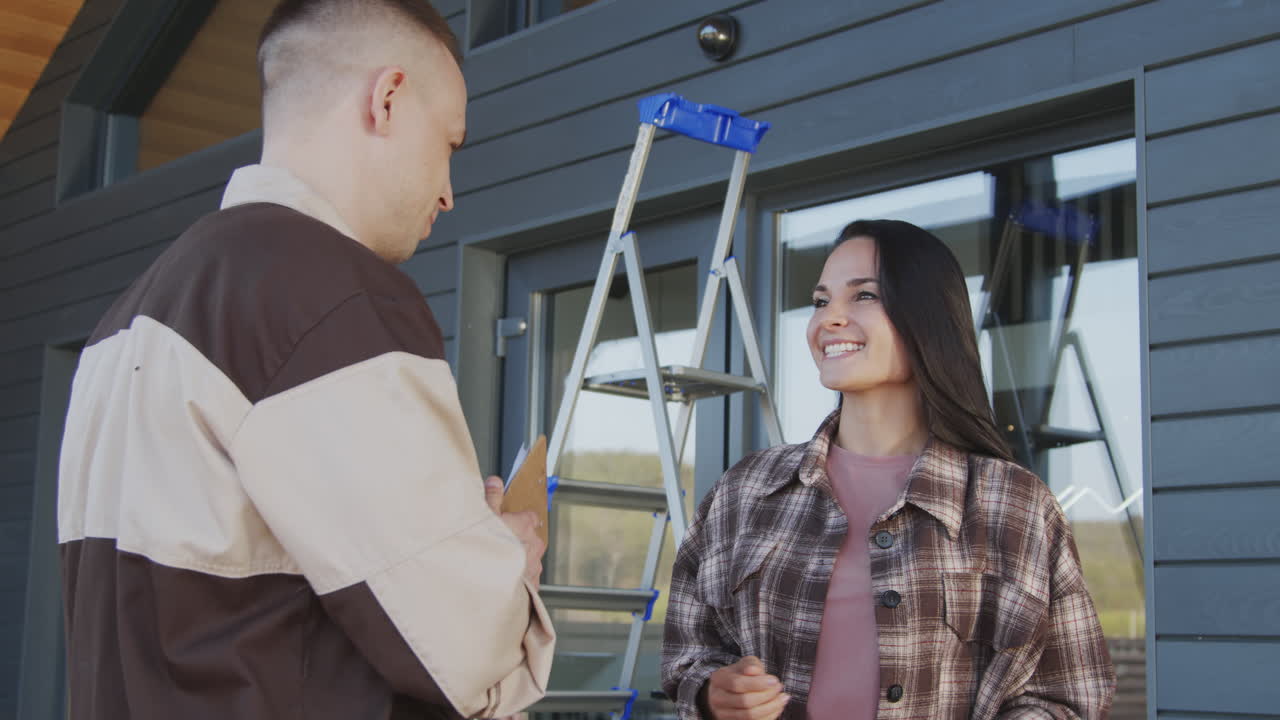 Woman Shaking Hands with Workers Installing Home Security