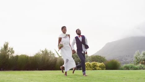 Feliz-Pareja-Afroamericana-Tomados-De-La-Mano-Y-Saltando-Durante-La-Boda