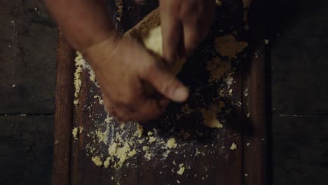 una foto aérea de una mujer amassando masa de chipa paraguaya en una mesa de madera