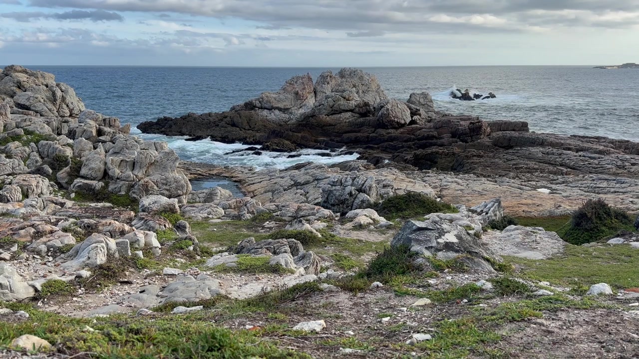 Onde che si infrangono contro le rocce frastagliate di Hermanus in Sudafrica