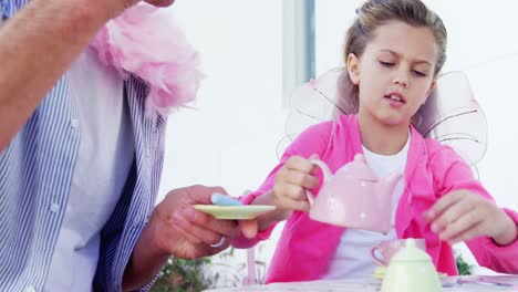 smiling father and daughter in fairy costume having a tea party 4k