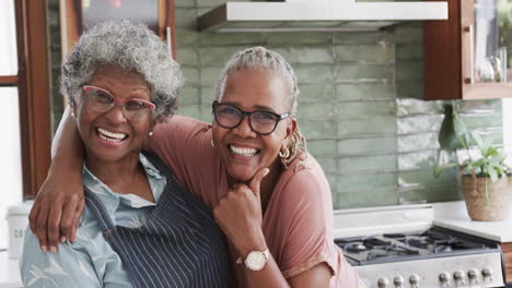portrait of happy senior african american female friends cooking in kitchen, copy space, slow motion