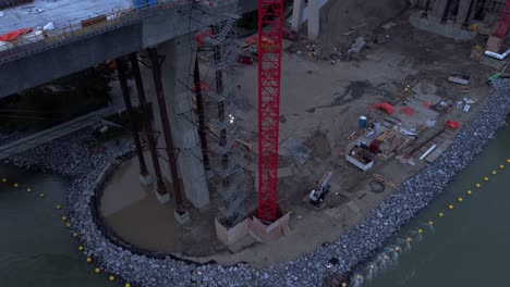 Crane-by-busy-highway-bridge-construction-zone-tilt