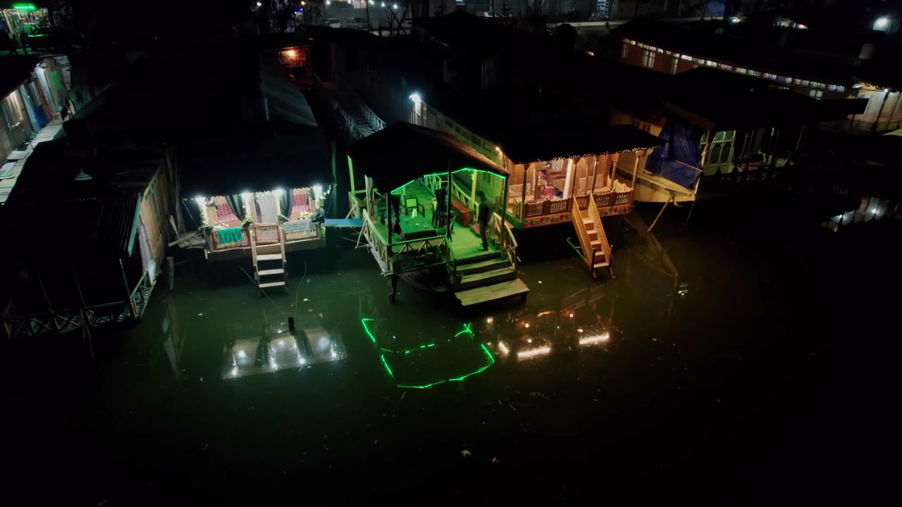 4k aerial view of house boats in dal lake pan shot during night pull back drone shot at srinagar, kashmir, india