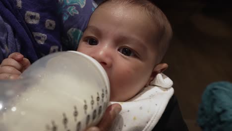 Adorable-2-Month-Old-Bangladeshi-Baby-Drinking-Milk-From-Bottle-As-He-Is-Being-Cradled