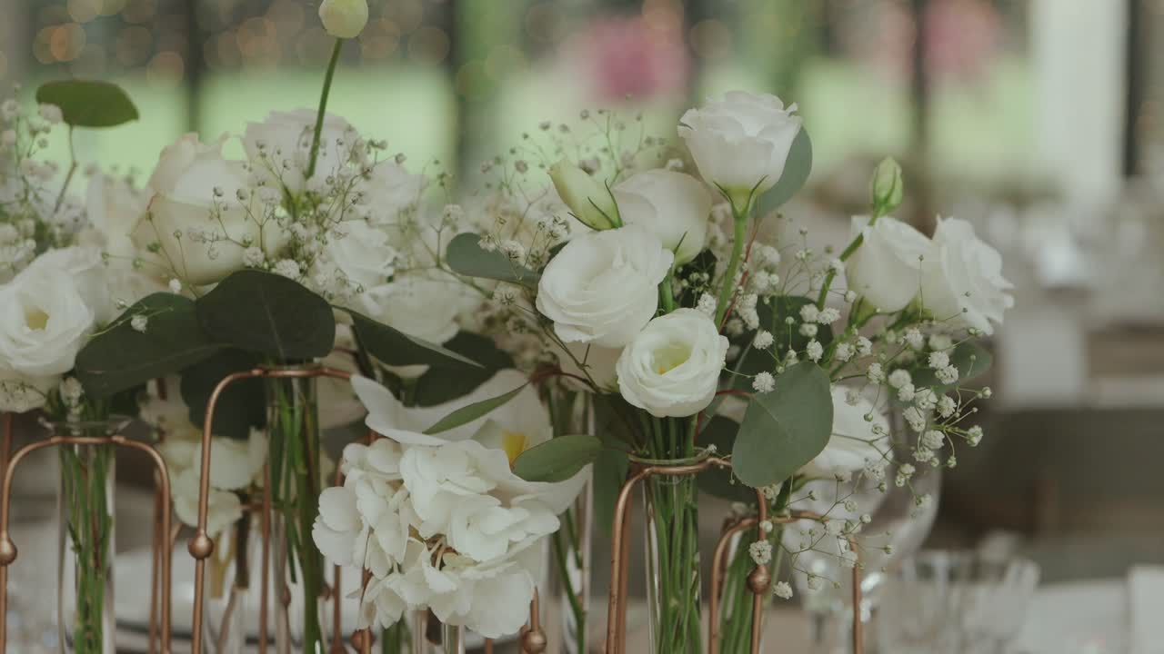 primo piano di fiori bianchi per matrimonio disposti con del verde sul tavolo