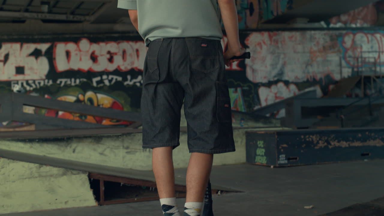 도시 스케이트 파크에서 스쿠터를 타는 스포츠 소년. 밖에서 연습하는 캐주얼 라이더