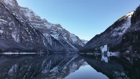 captivating view of klöntalersee in glarus, switzerland, reflecting the snow-covered vorderglärnisch and vrenelisgärtli peaks. a tranquil alpine paradise showcasing winter's pristine beauty