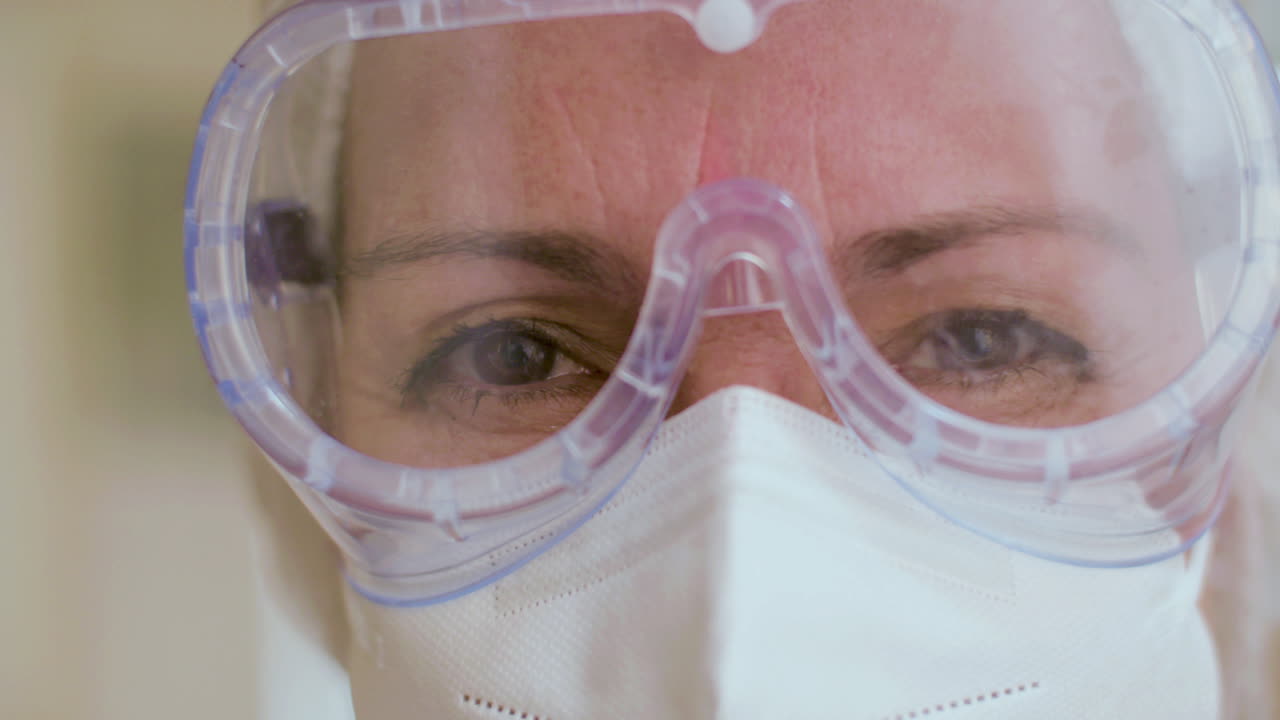 Primer plano de un médico alegre con gafas protectoras