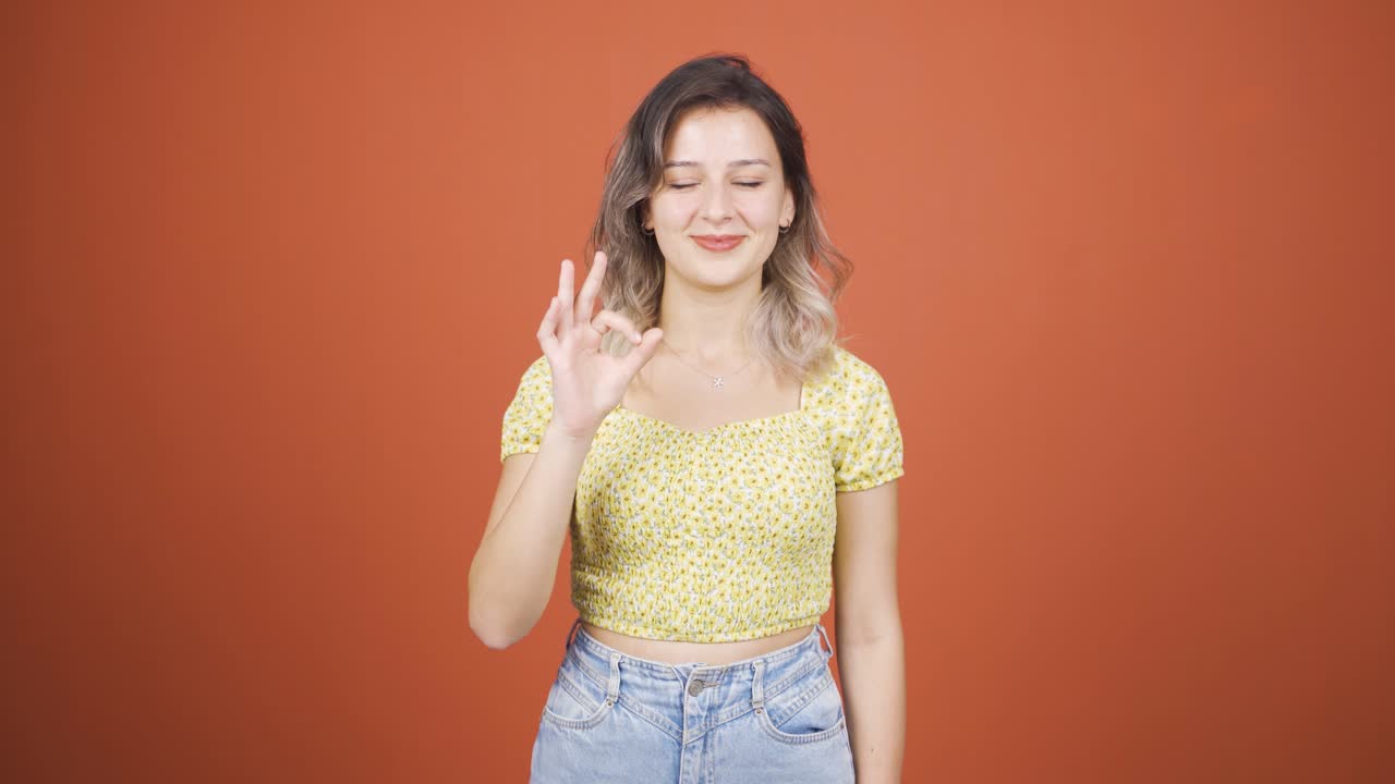 젊은 여성이 카메라에 긍정적인 제스처를 하고 있습니다.