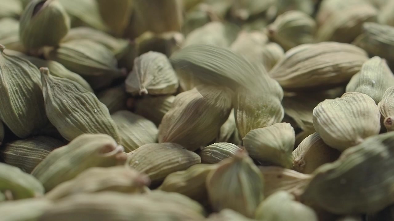 Primo piano di baccelli di cardamomo verde che cadono in un mucchio