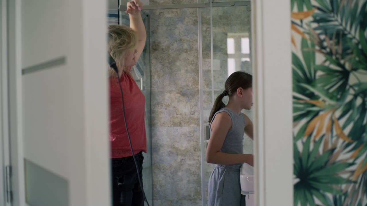 어머니와 딸이 욕실에서 준비하고 있습니다.