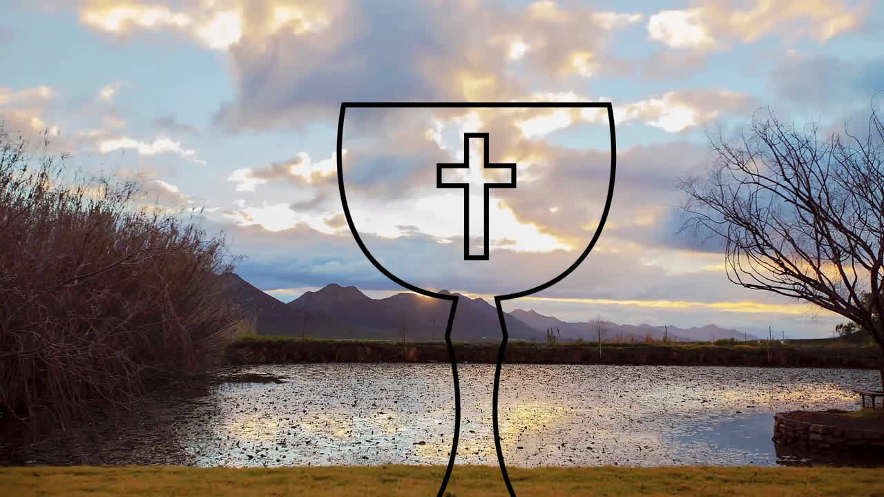 Over serene lake and mountain landscape at sunset, chalice with cross outline