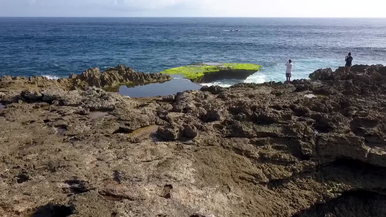 impresionante vista aérea vuelo volar hacia adelante toma de drones de una gran ola oceánica estrellándose contra las rocas de la lágrima del diablo en lembongan
