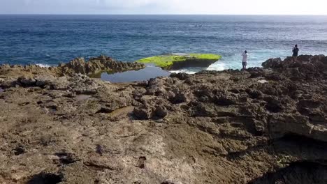 Impresionante-Vista-Aérea-Vuelo-Volar-Hacia-Adelante-Toma-De-Drones-De-Una-Gran-Ola-Oceánica-Estrellándose-Contra-Las-Rocas-De-La-Lágrima-Del-Diablo-En-Lembongan