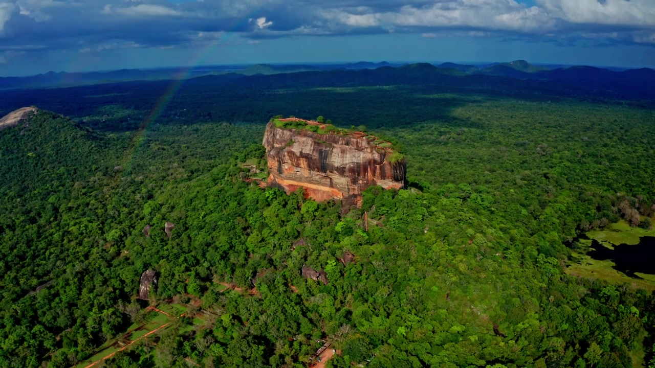 Filmatiske luftopptak av Sigiriya med en regnbue som buer seg over den eldgamle fjellfestningen og den omkringliggende srilankiske jungelen