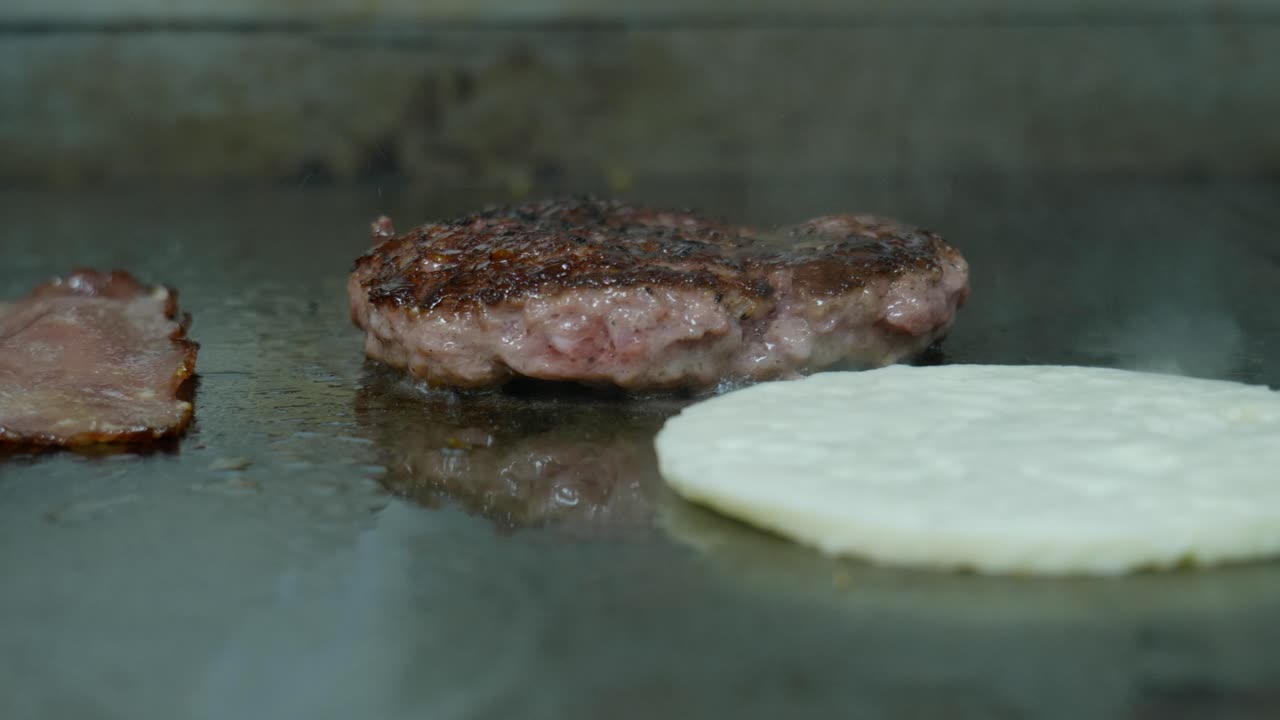 carne de hamburguesa a la parrilla, halloumi y tocino en una sartén caliente