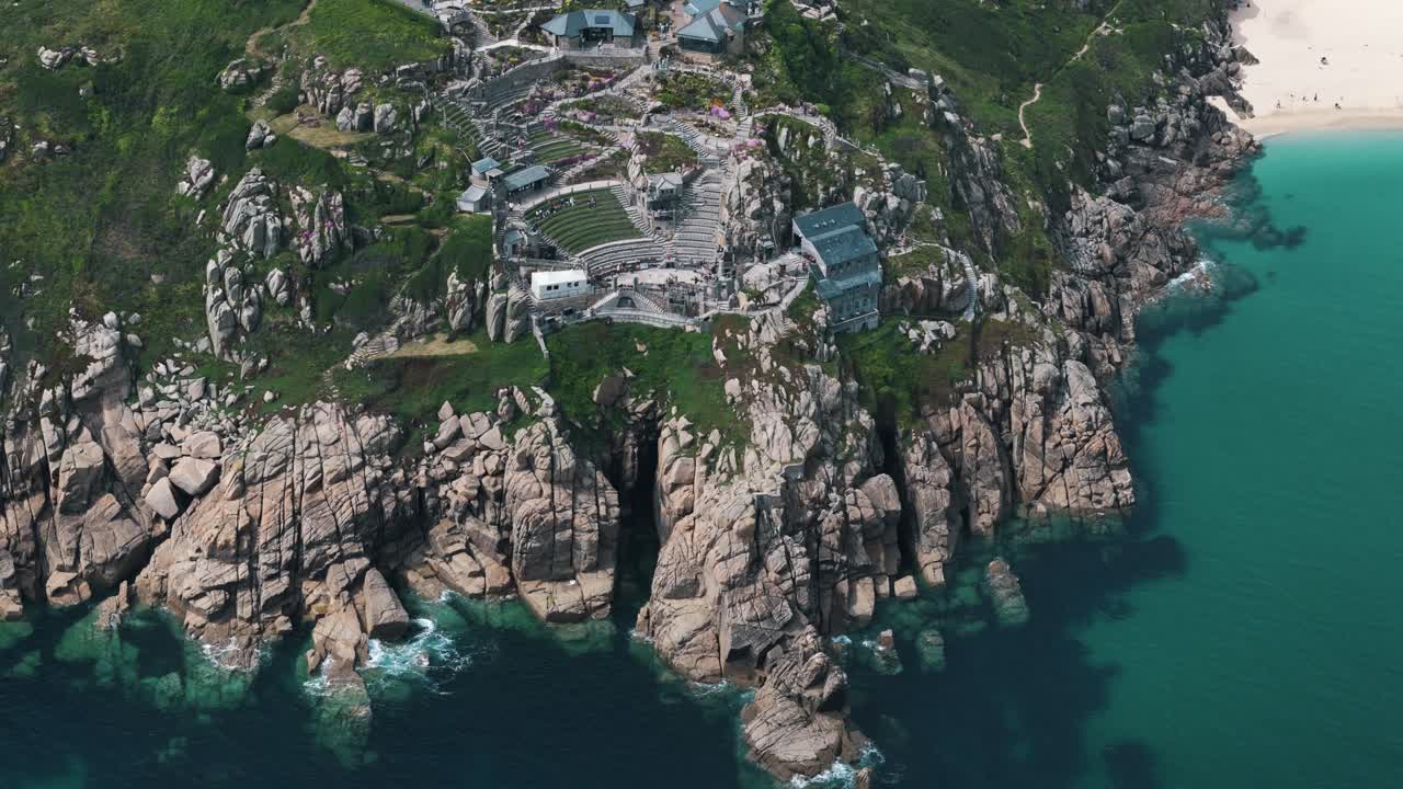 High dolly right above Minack Theatre revealing turquoise waters and beach