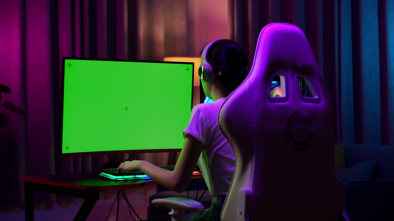 Giocatrice adolescente asiatica perde mentre gioca a un videogioco al computer con green screen.