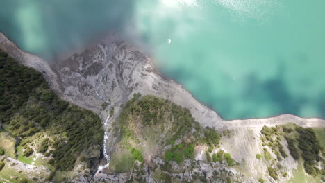 Top-down-flyover-depicting-the-rivers-of-melting-water-flowing-into-the-Oeschinesee-close-to-Kandersteg,-Switzerland