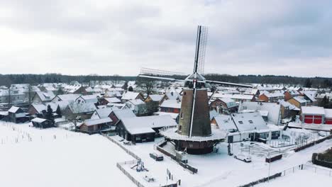 drone over dutch winter windmill covered in snow, all covered under ice during extreme winters