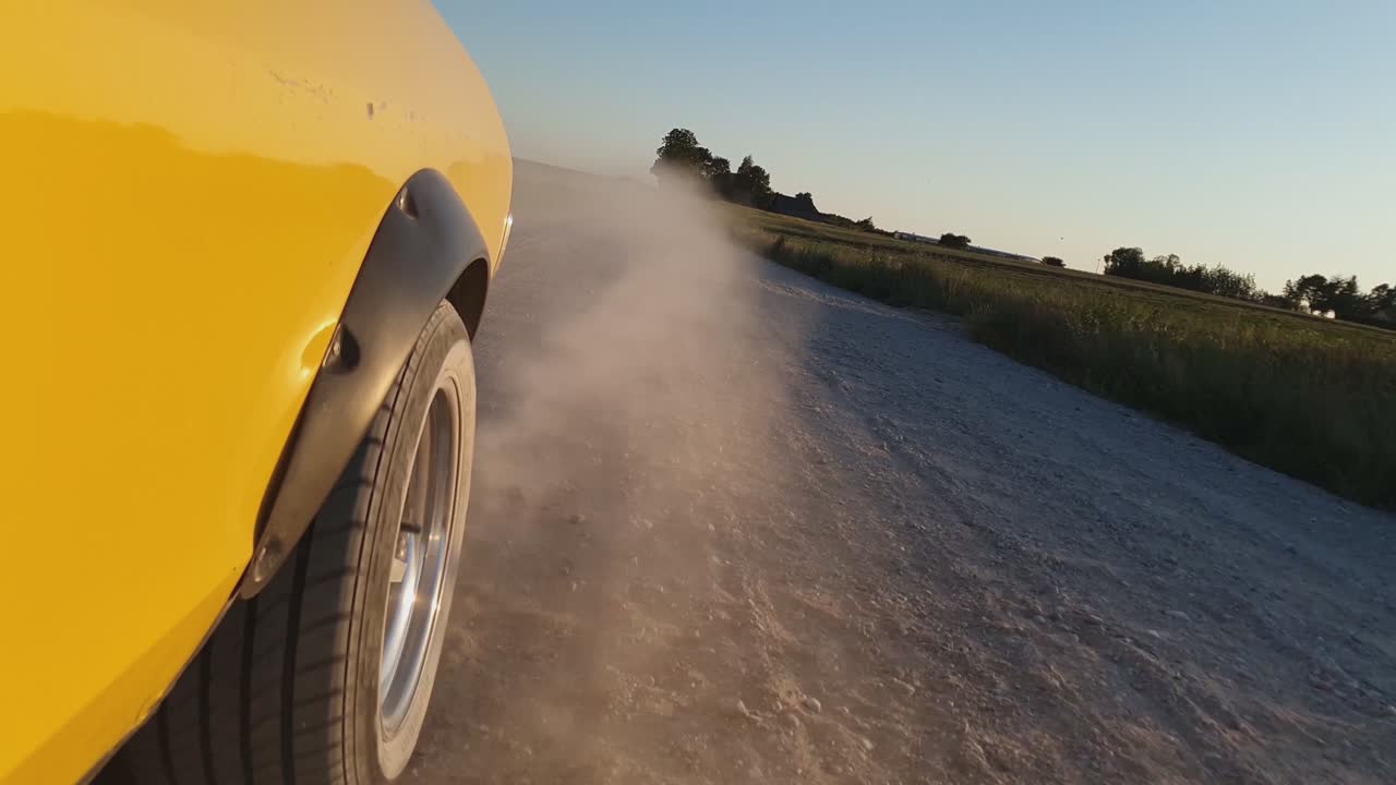 먼지가 많은 시골 자갈길에서 노란색 빈티지 자동차 드라이브-1