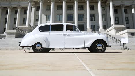 slow pan of white princess rolls limo in front of utah state capitol building